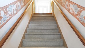 A staircase with a wooden handrail and a floral pattern on the walls. - Villa Anna in Monferrato (Rosignano Monferrato)