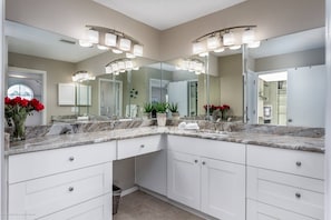 A modern bathroom with a double sink vanity, large mirrors, and a potted plant. - Siesta Bayside With Bay/dock Views (Siesta Key)