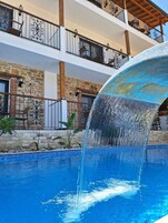 Una piscina al aire libre de temporada, sombrillas