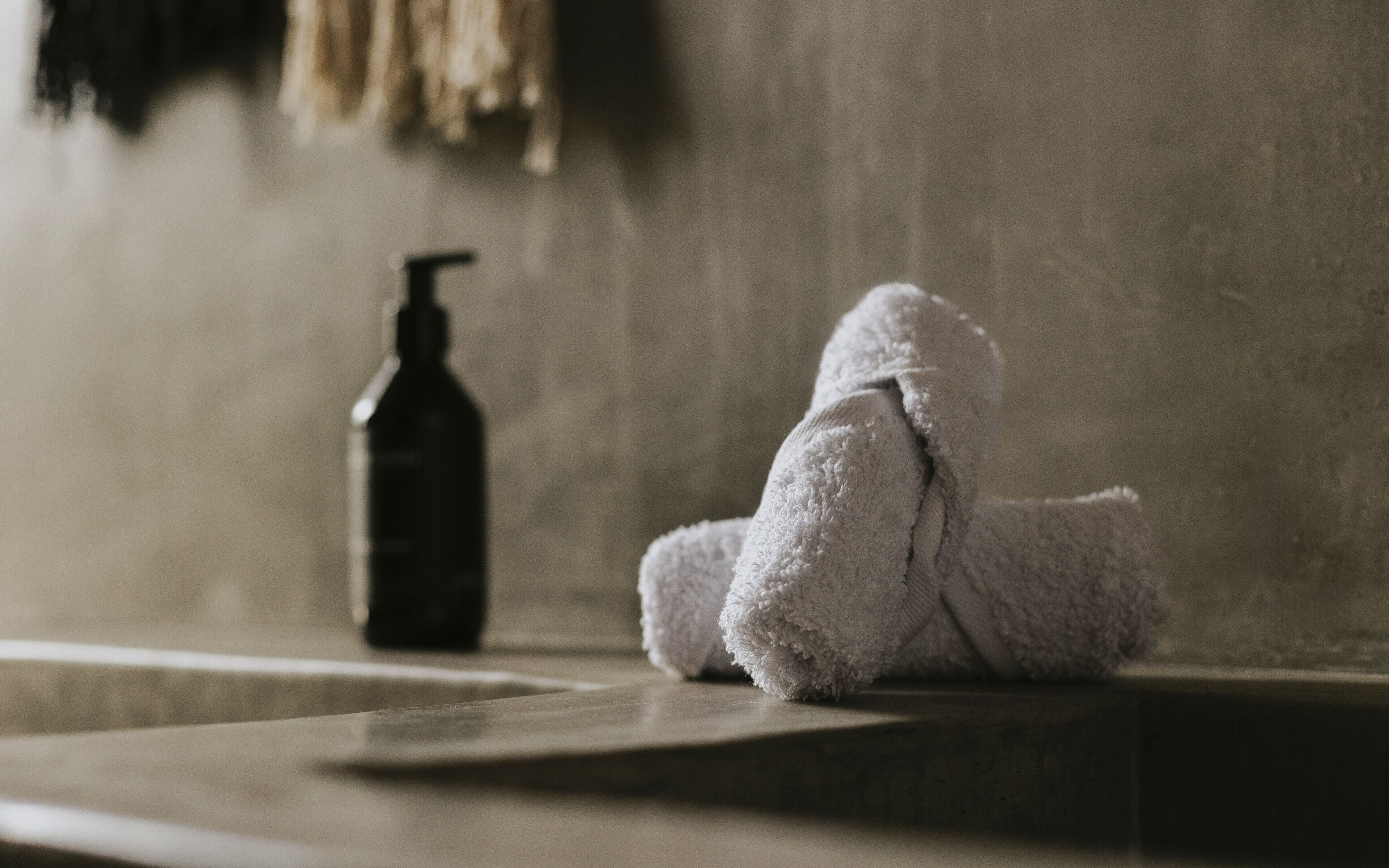 Ein Badezimmer mit einem Handtuch und einer Seifenspender auf einer Ablagefläche.