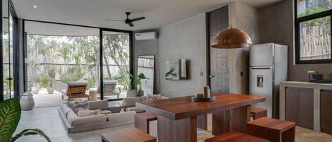 A modern kitchen with a central island, wooden stools, and a large pendant light.