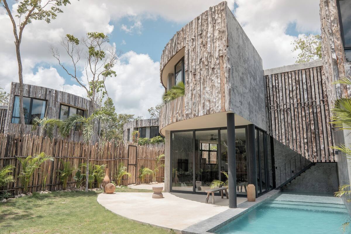 Uma casa moderna com piscina, janelas amplas e fachada de madeira.