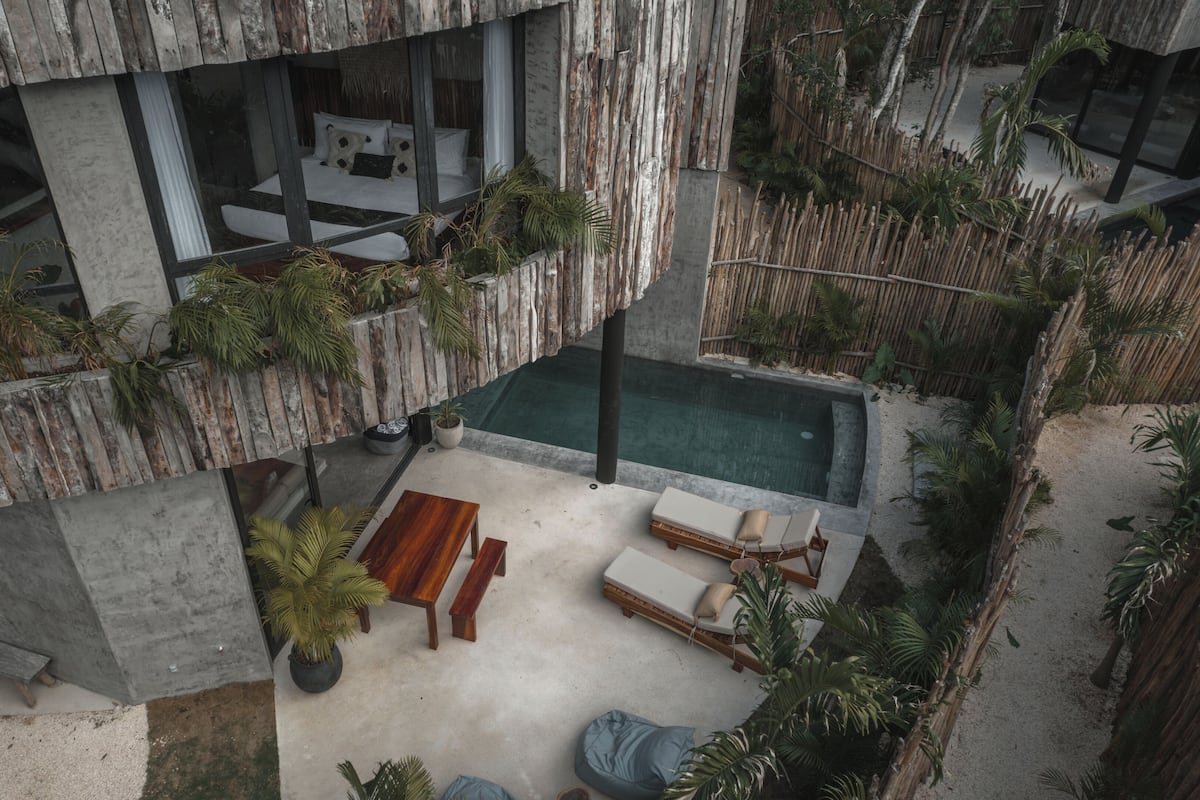 Um edifício moderno com um jardim no terraço, piscina e área de estar ao ar livre.