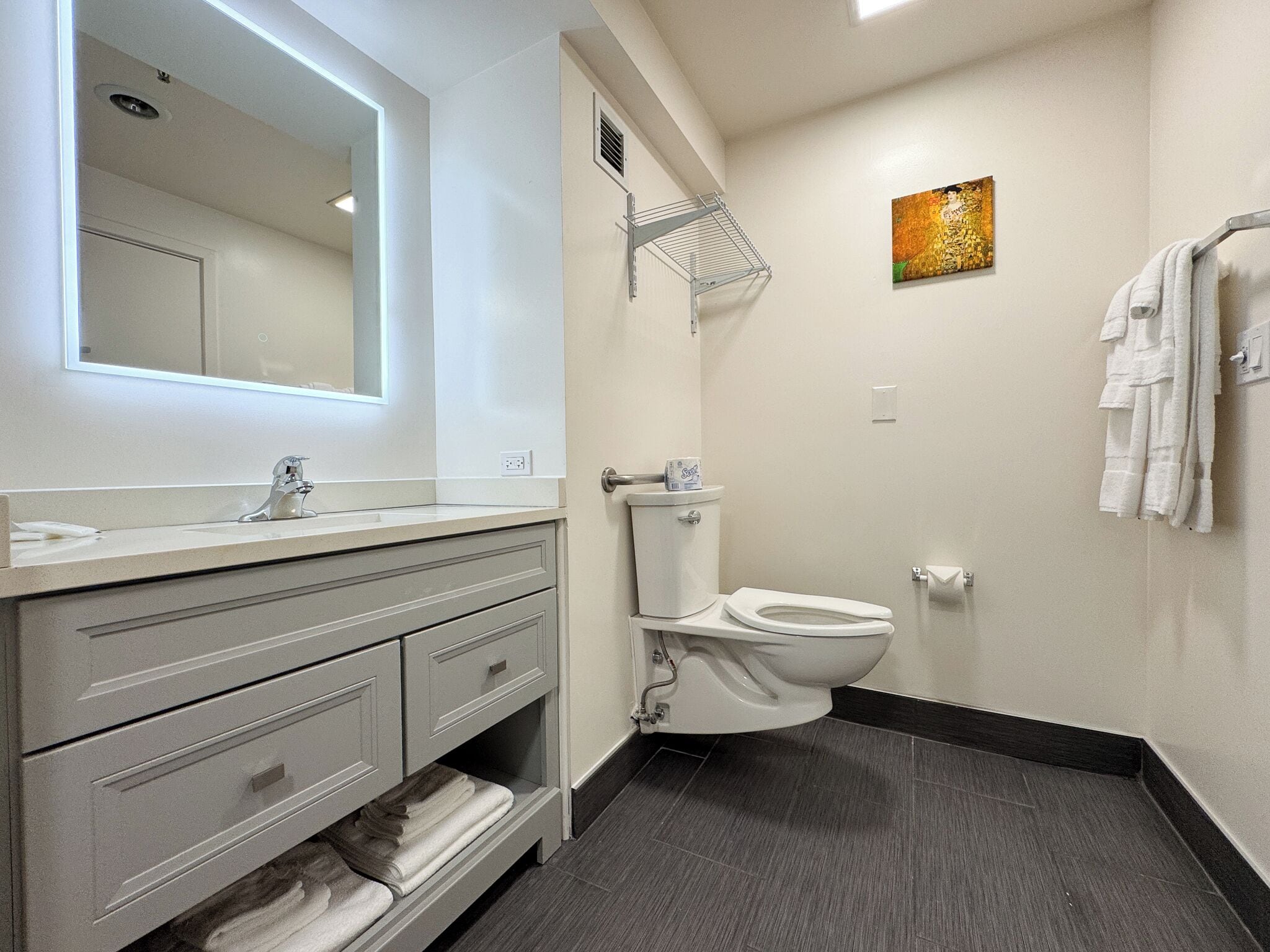 Uma casa de banho moderna com toucador branco, sanita e zona de duche.