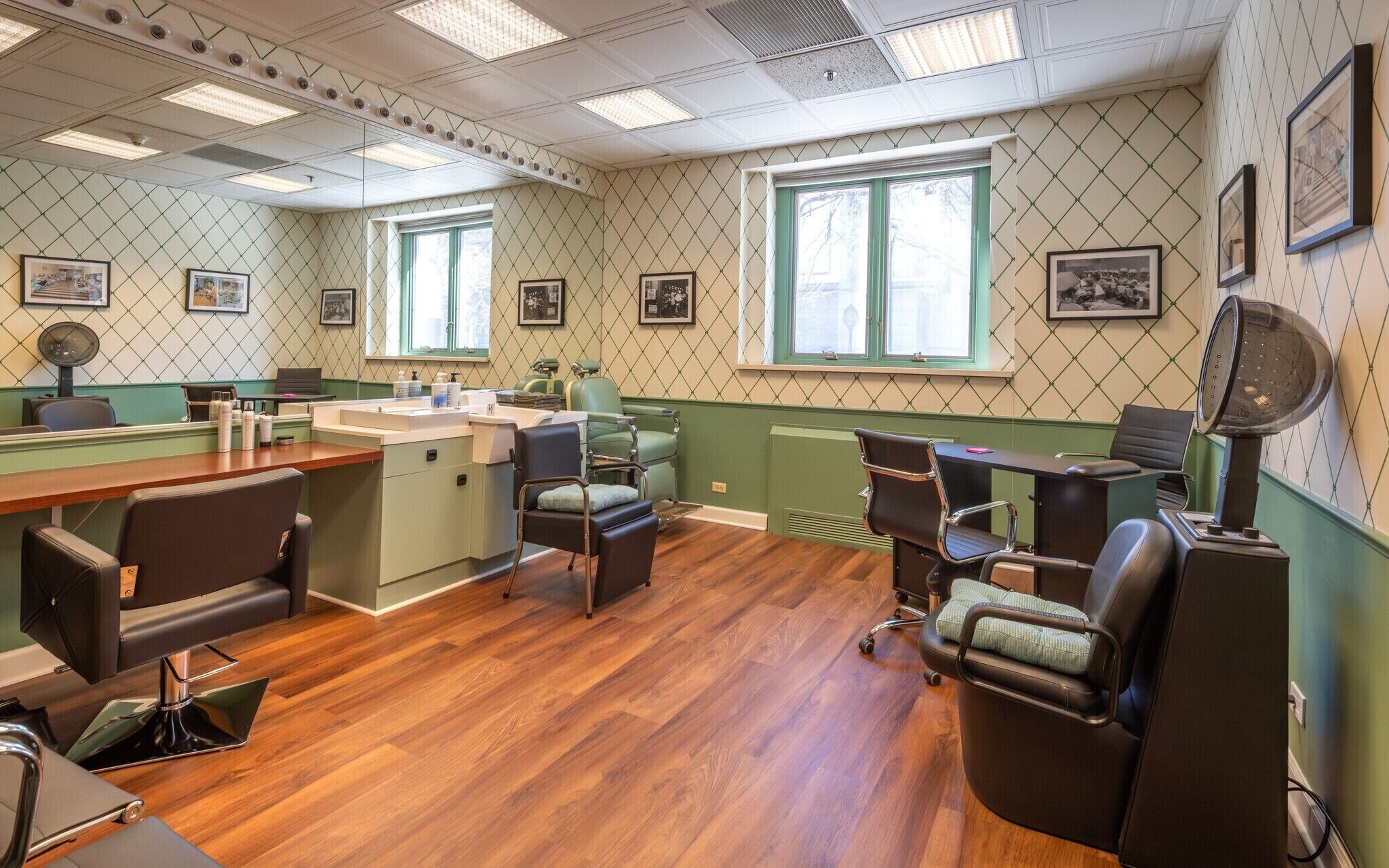 Un salón con una mesa de recepción, varias sillas e imágenes enmarcadas en las paredes.