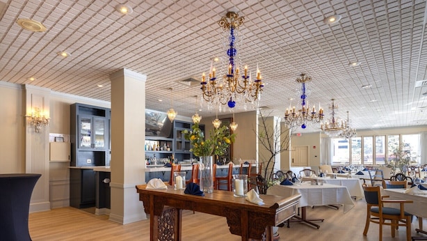 A spacious hotel lobby with a high ceiling, chandeliers, and a bar area. - The Gem Museum Suites (Evanston)