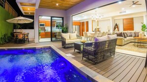 A modern living area with a pool, outdoor furniture, and a view into the kitchen. - Brand New Luxury Villa on the South End of Jaco Beach, Steps from the Beach! (Jaco)