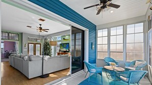 Un salon moderne avec un canapé, des fauteuils bleus et une table à manger.