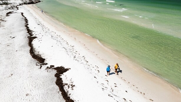 Une plage avec une eau claire et un sentier de sable.