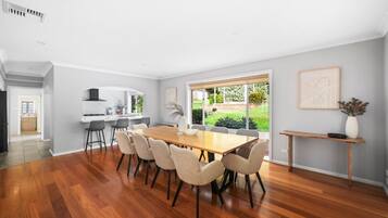 A modern kitchen with a built-in oven and a dining area with a wooden table and chairs.