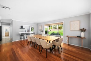 A modern kitchen with a built-in oven and a dining area with a wooden table and chairs.