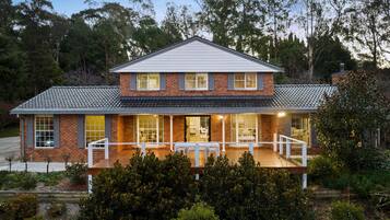A two-story house with a covered porch and a brick exterior.