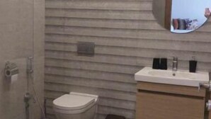 Een moderne badkamer met douche, toilet en wastafel.