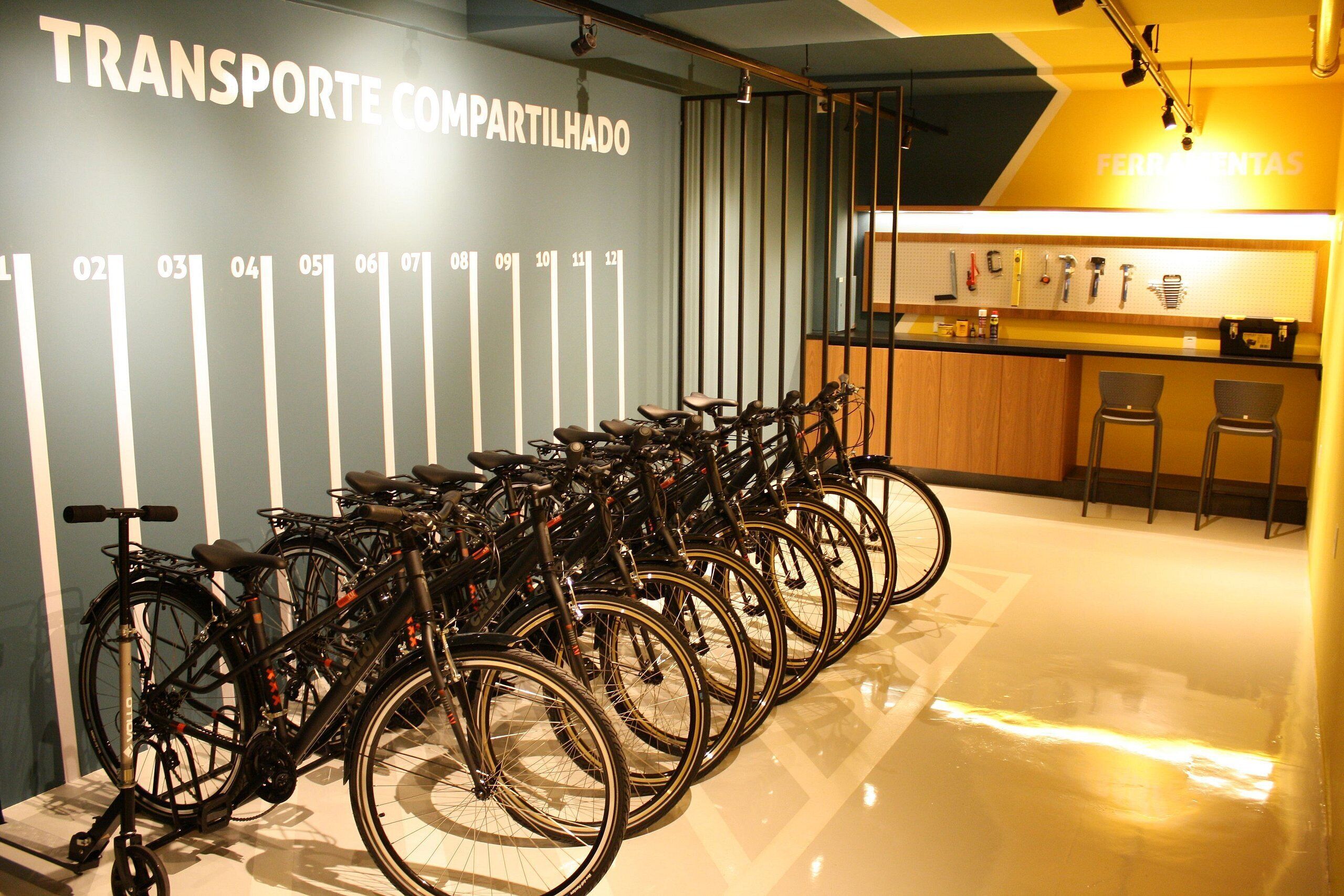 A bike rental station with multiple bicycles and a counter area in the background.