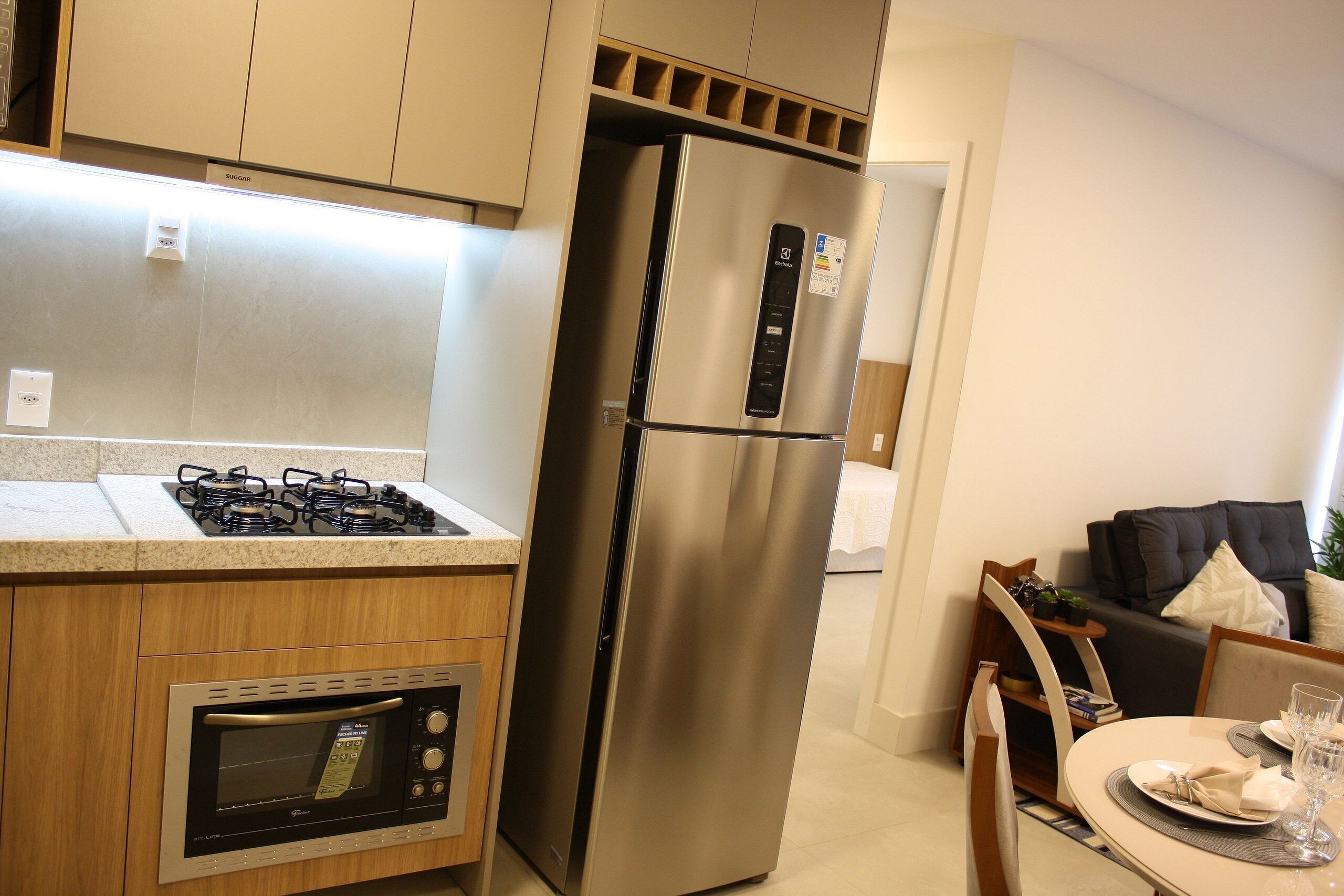 A modern kitchen with a stainless steel refrigerator, built-in oven, and gas stove.