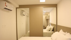 Une chambre d’hôtel avec un lit, un miroir et une armoire.