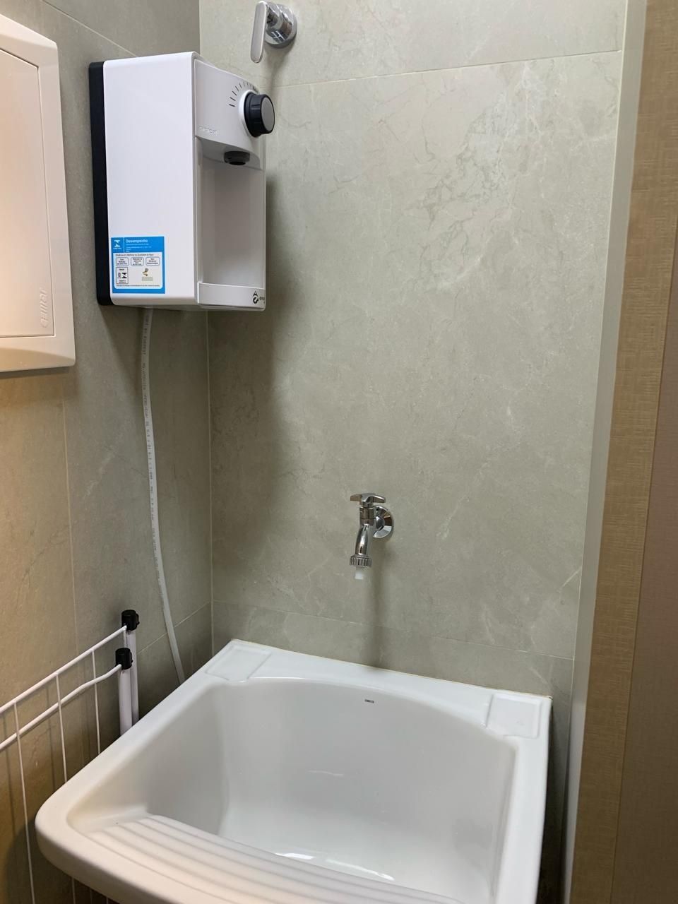 A bathroom with a white bathtub, a wall-mounted heater, and a faucet.
