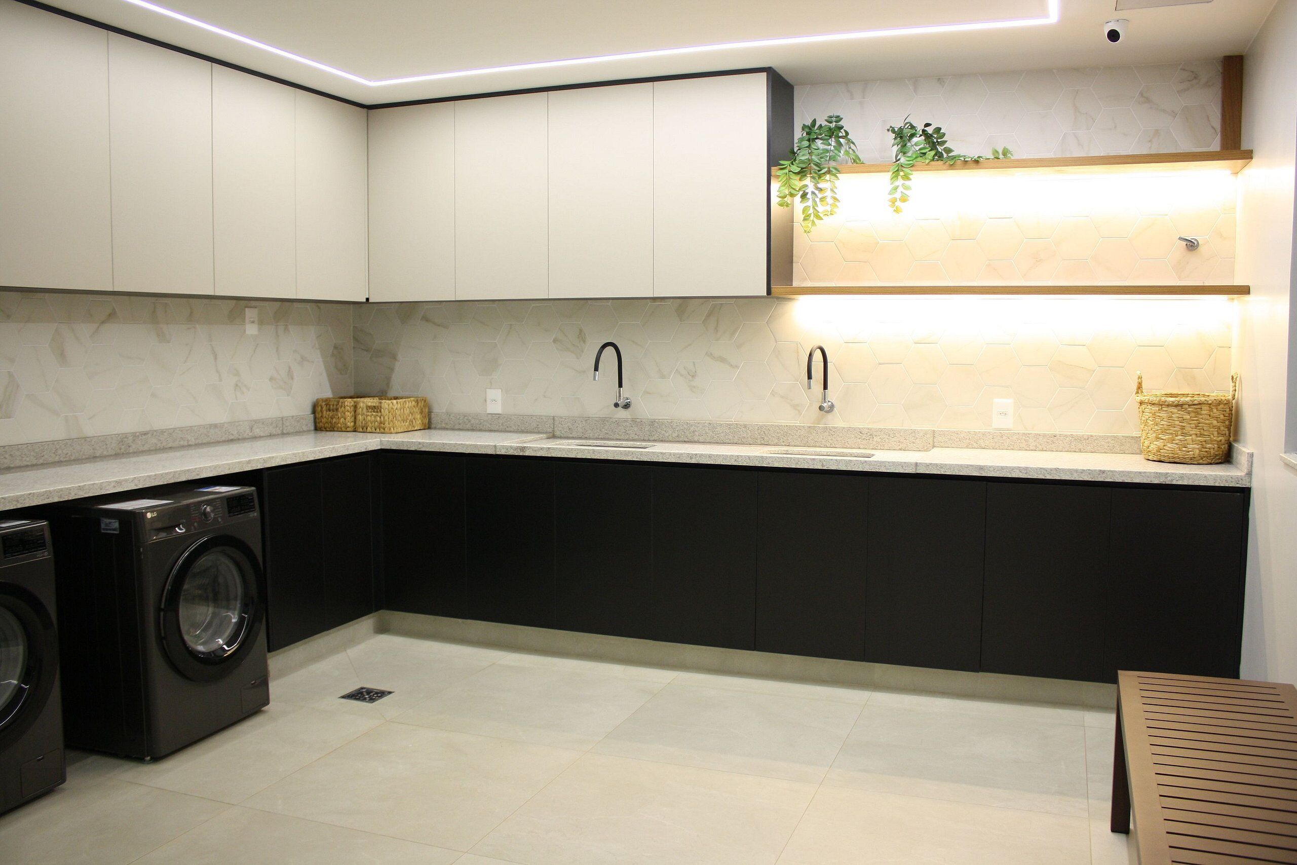 Een moderne keuken met een ingebouwde wasmachine, donkere kastjes en een licht aanrecht.