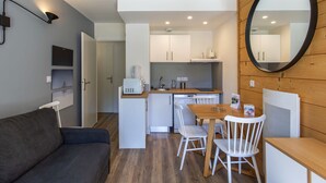 A compact living space with a kitchenette, a dining area, and a seating area.