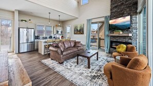 A spacious living area with a fireplace, a sofa, and a coffee table. - NEW LAKE CABIN Sleeps 14 Indoor Pool Hot Tub (Sevierville)