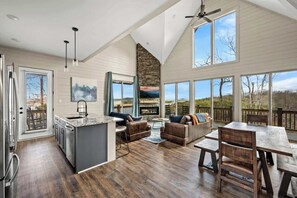 A spacious living area with a kitchen, dining table, and seating.