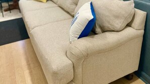 A beige sofa with a blue and white pillow, a wooden coffee table, and a small lamp. - Lake Life Lodge Cottage by Belton Lake (Belton)