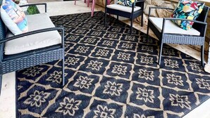 A covered patio area with outdoor furniture, a patterned rug, and a view of the surrounding greenery. - Lake Life Lodge Cottage by Belton Lake (Belton)