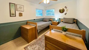 A compact room with two single beds, a ceiling fan, and a small table with a plant. - Lake Life Lodge Cottage by Belton Lake (Belton)