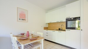 A modern kitchen with white cabinets, a wooden countertop, and a built-in oven.