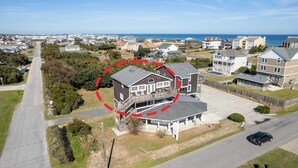 Zona residencial con casas, una calle y una playa al fondo.