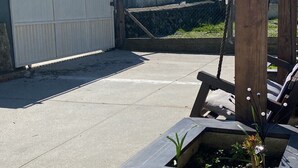 A paved area with a stone planter, a wooden post, and a metal gate. - Apartment 'Alojamento D Duarte T1' with Mountain View, Balcony and Wi-Fi (Gouveia)
