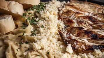 Un plato de comida con pasta, pollo y pan.