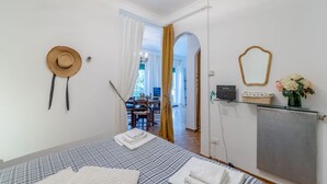 Un dormitorio con una cama, un sombrero, un espejo y un radiador.