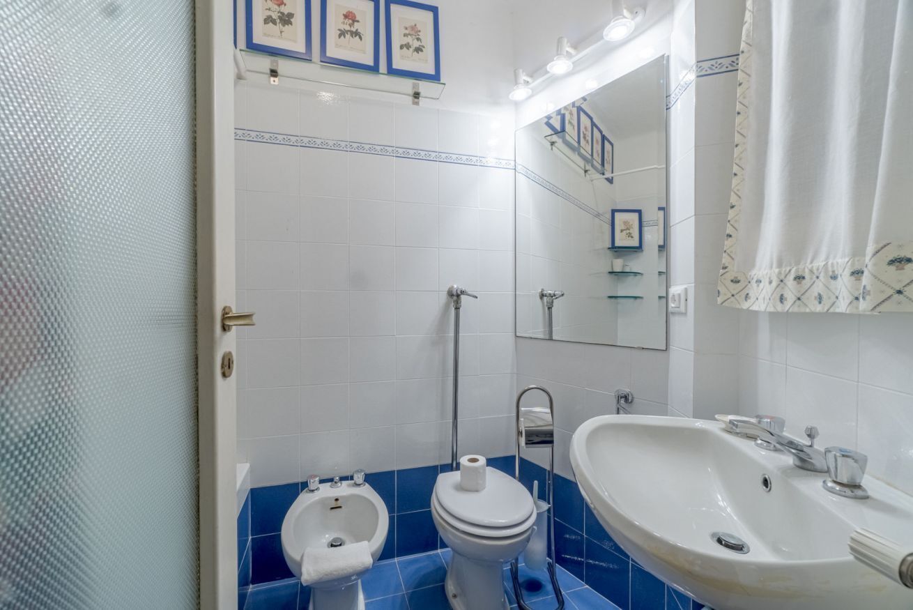 Un baño con inodoro, bidé, lavabo y espejo.