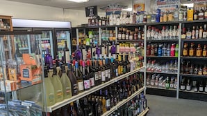 Een slijterij met schappen vol verschillende soorten alcoholische dranken.