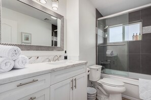 A modern bathroom with a white vanity, a large mirror, a glass shower enclosure, and a toilet. - Spacious & Comfortable w/Prime Location Sleeps 12 (Scottsdale)
