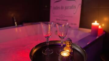 A tray with two glasses and a candle on a table, with a sign in the background.