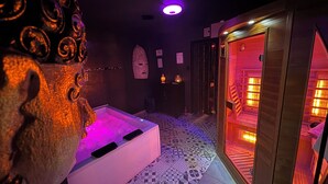 Ett spa-rum med en massagebänk, en bastu och en dekorativ skulptur i form av ett huvud.