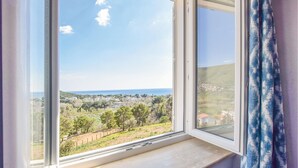 A window with a view of a coastal landscape, including houses and greenery. - 2 bedroom stunning apartment in Ogliastro Marina (Ogliastro Marina)