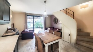 Une cuisine moderne avec un coin repas, un escalier et une grande fenêtre.