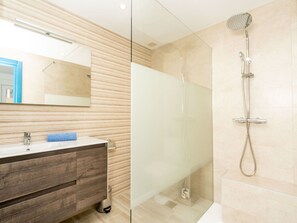 A modern bathroom with a glass shower enclosure, a wooden vanity, and a large mirror. - Beautiful apartment for 2 people with WIFI, A/C, TV and terrace (Xàbia)
