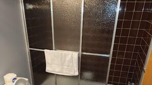 A bathroom with a shower, toilet, and sink. - The Weekender Unit #2 (Geneva-on-the-Lake)