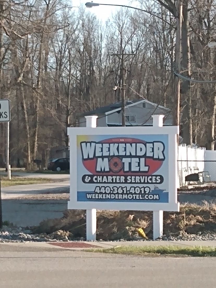 A sign for Weekender Motel advertising charter services and a contact number.