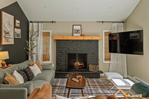 Smart-tv, eldstad, tv-spel och ett bordtennisbord