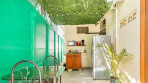 A compact kitchen with a refrigerator, a sink, and a small countertop with various items. - ¡Acogedora habitación privada en el corazón de Quepos! (Quepos)