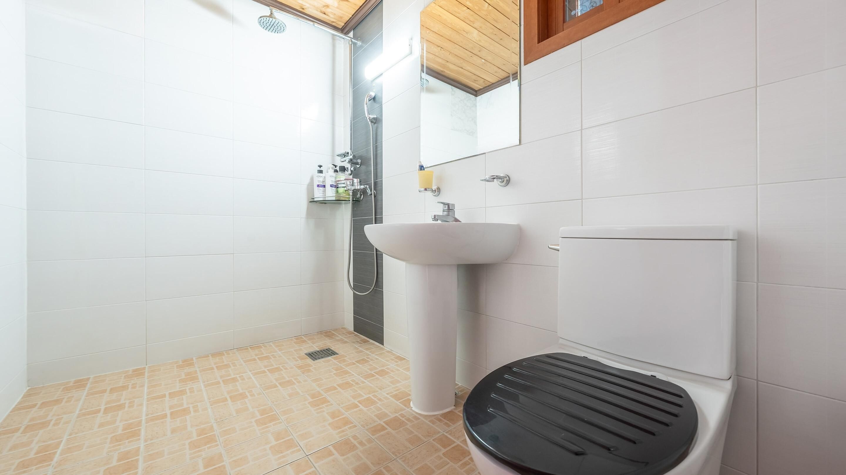 A bathroom with a shower, toilet, and sink.