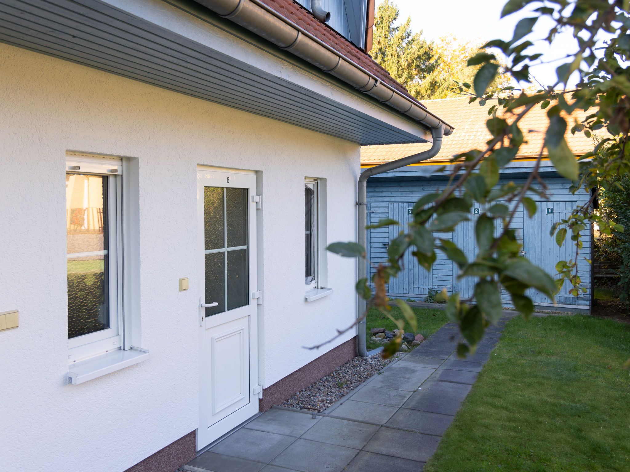 A house with a white exterior, a front door, and two windows.