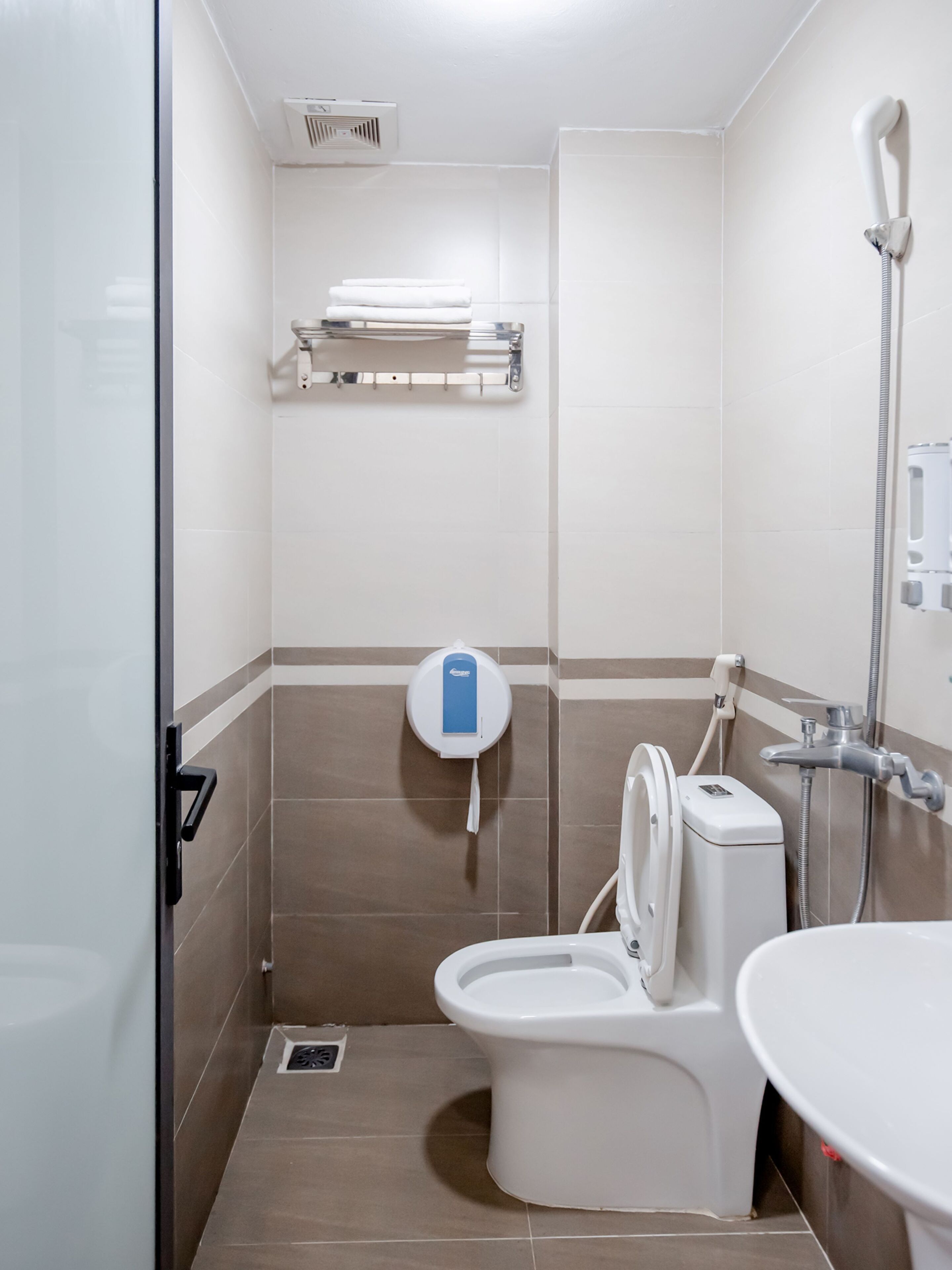 A bathroom with a toilet, a shower, and a sink.