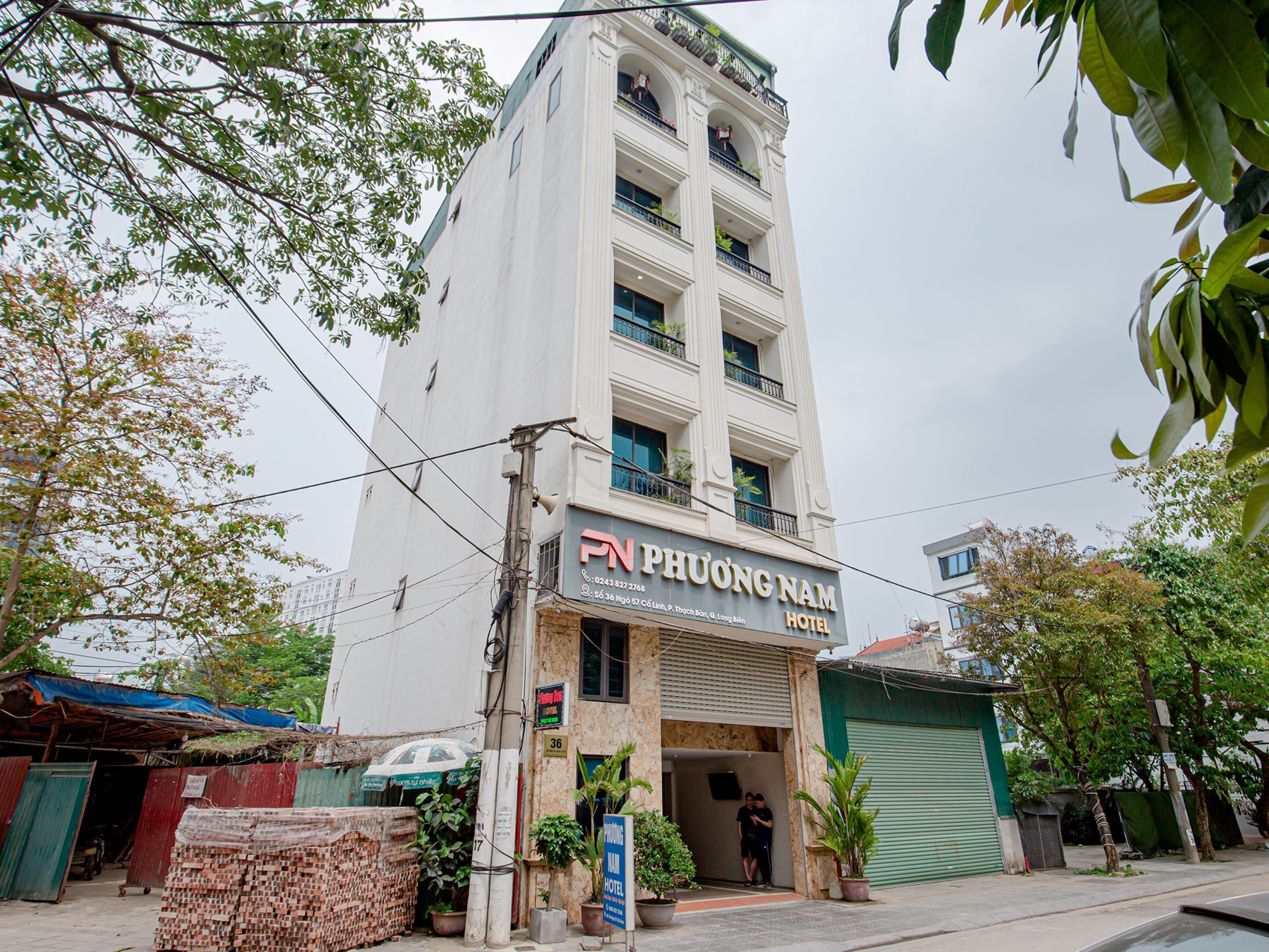 Un hotel con un letrero que dice "PN Phuong Nam Hotel" y una entrada visible.