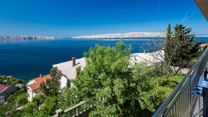 A balcony with a view of a coastal landscape, including a body of water and distant hills. - Lovely apartment for 3 guests with A/C, WIFI, TV and balcony (Senj)